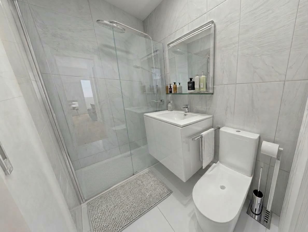 Baño reformado en Vitoria con ducha a ras de suelo y azulejo claro
